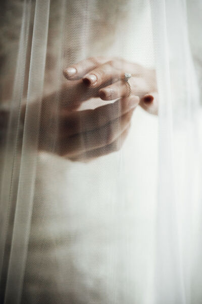 Veil covers bride’s hands with wedding rings Veil covers bride's hands with wedding rings